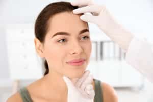 Woman having her face examined for scaring after Mohs surgery in Calgary, AB