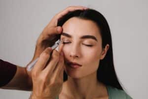 Doctor's hands marking a woman's eyelids for an eyelid lift in Calgary, AB