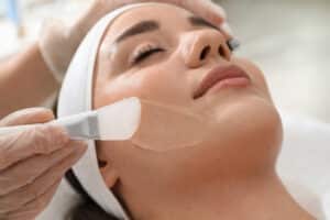 Woman receiving a facial chemical peel treatment.
