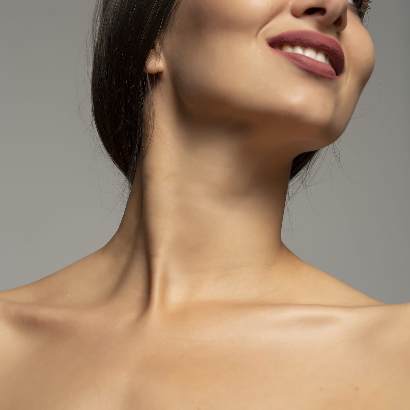 mouth, neck and bare shoulders of a smiling woman